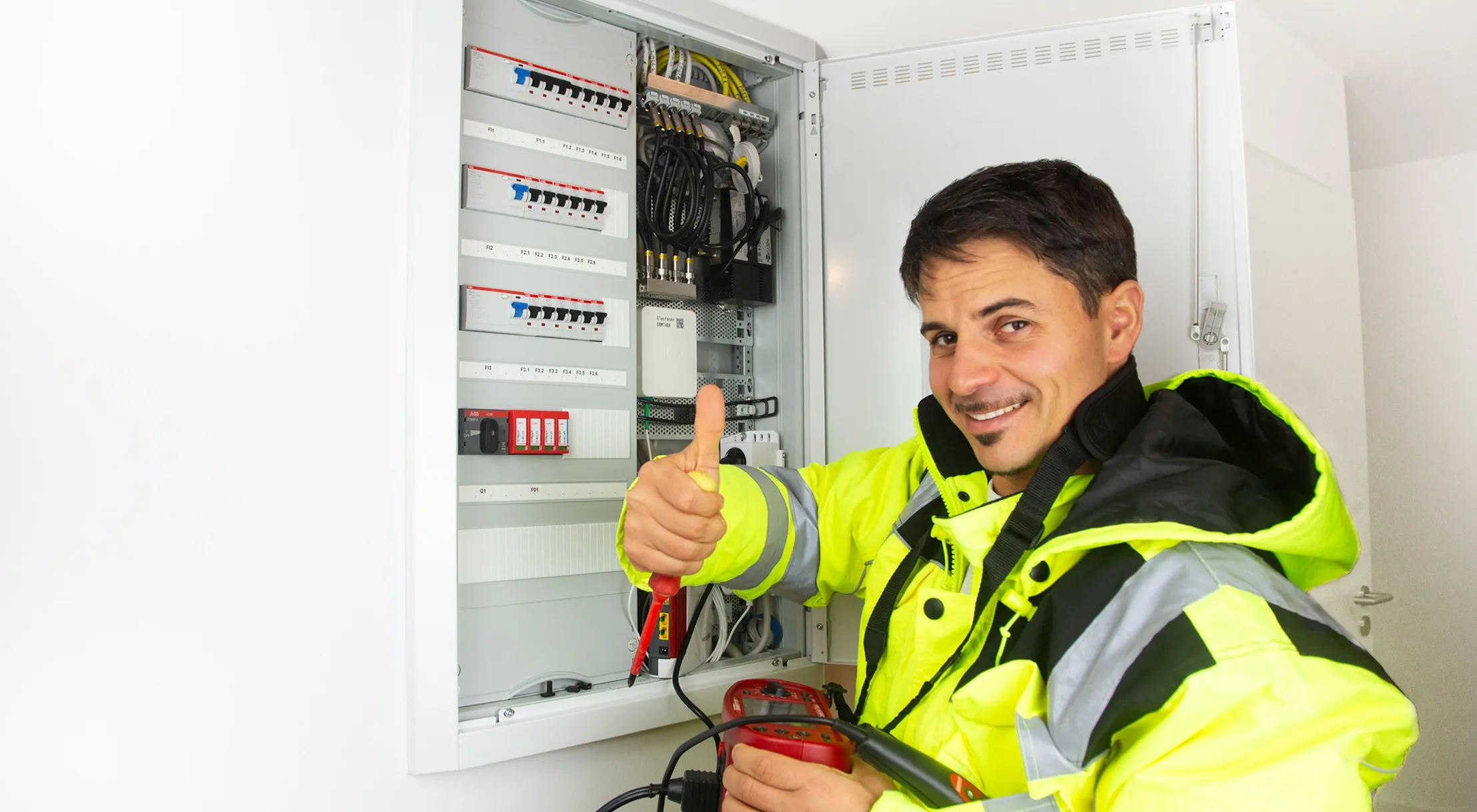 Elektrotechniker vor einer geöffneten Elektroverteilung